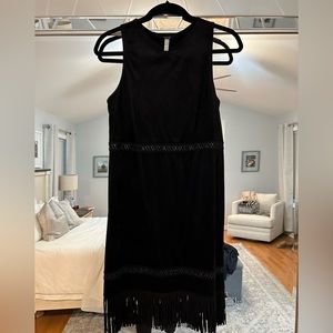 Black suede like fabric dress with leather stitching details and fringe bottom.